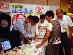 企業ブースで新開発のとうふの試食を行っている様子の写真