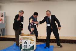 3人の方が壇上で鏡開きを行っている写真