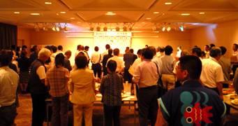 ステージ上を注目する来場者を写した会場の写真