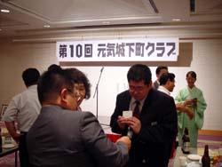 会場の演壇前で名刺交換を行う参加者たちの写真