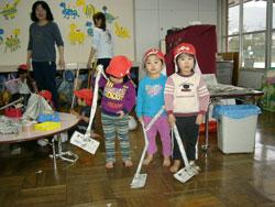掃除機を持っている子供3人の写真