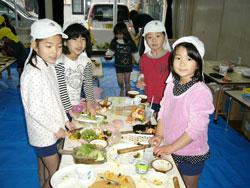 テーブルで料理を作っている子供たちの写真