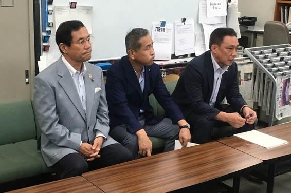 スーツ姿の3人の男性が質問に答えている写真