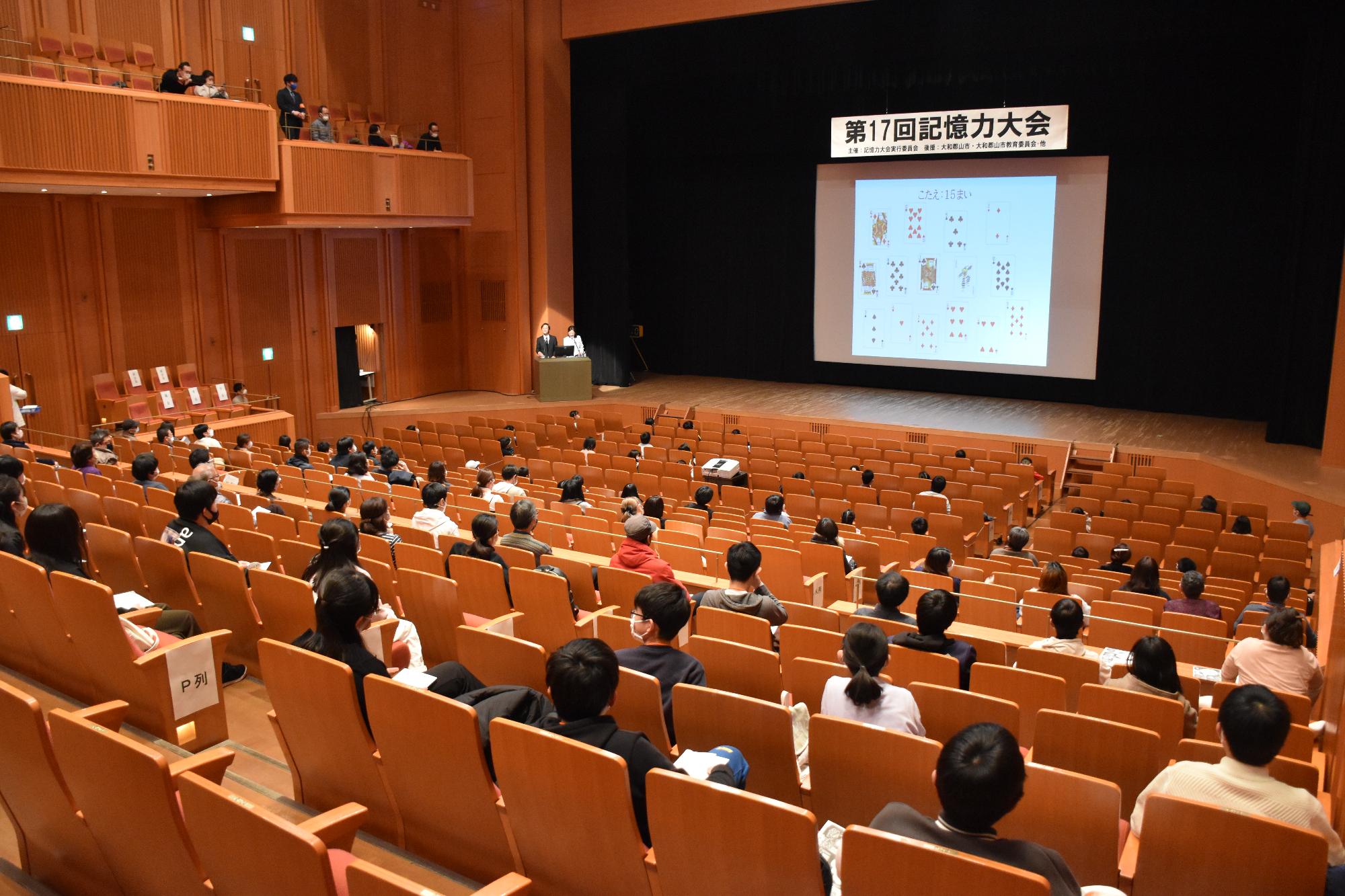 記憶力大会協議の部でスクリーンに映されている問題を見る参加者の様子