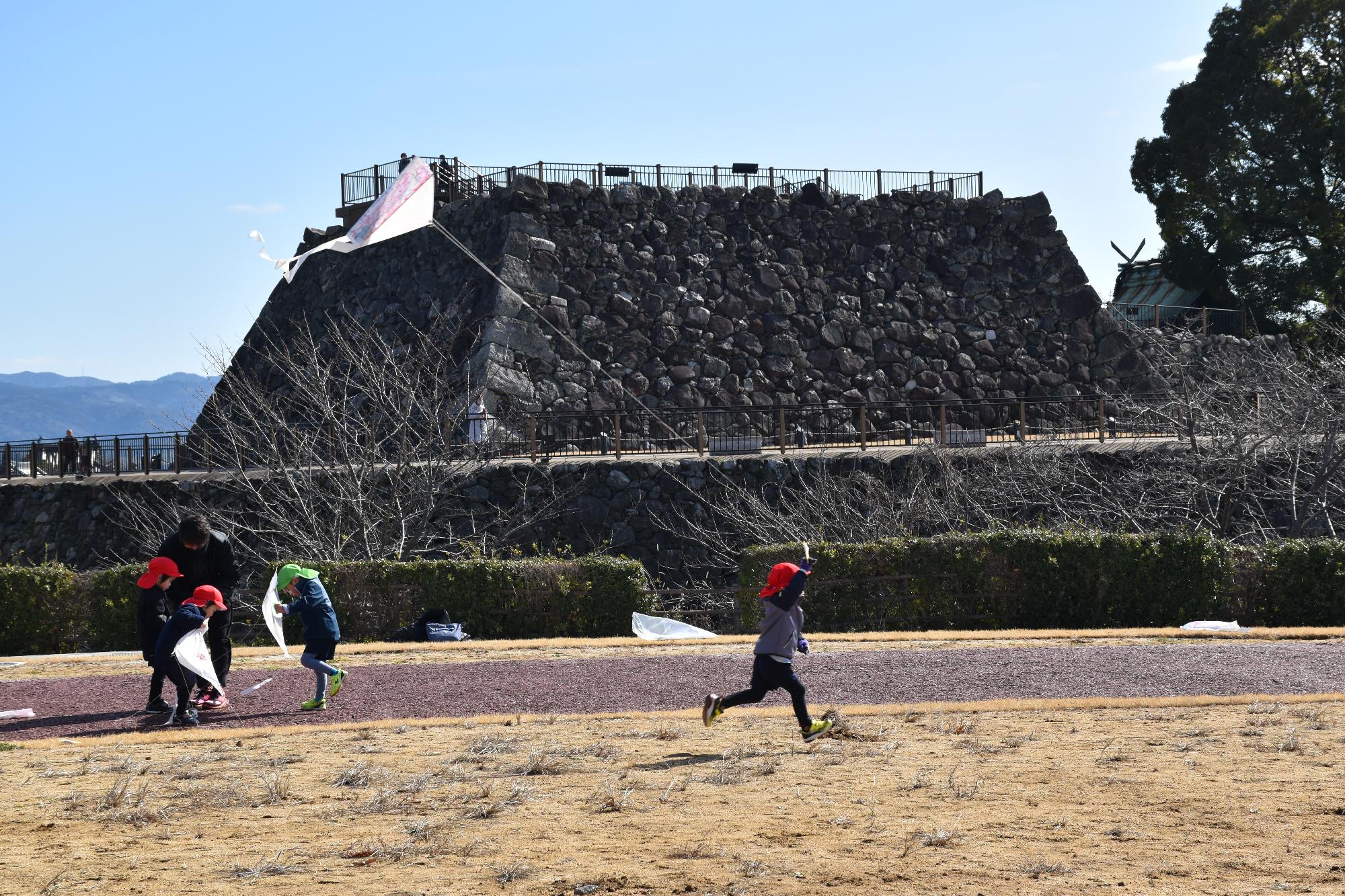 郡山西幼稚園の園児が厩広場で凧揚げをしている様子