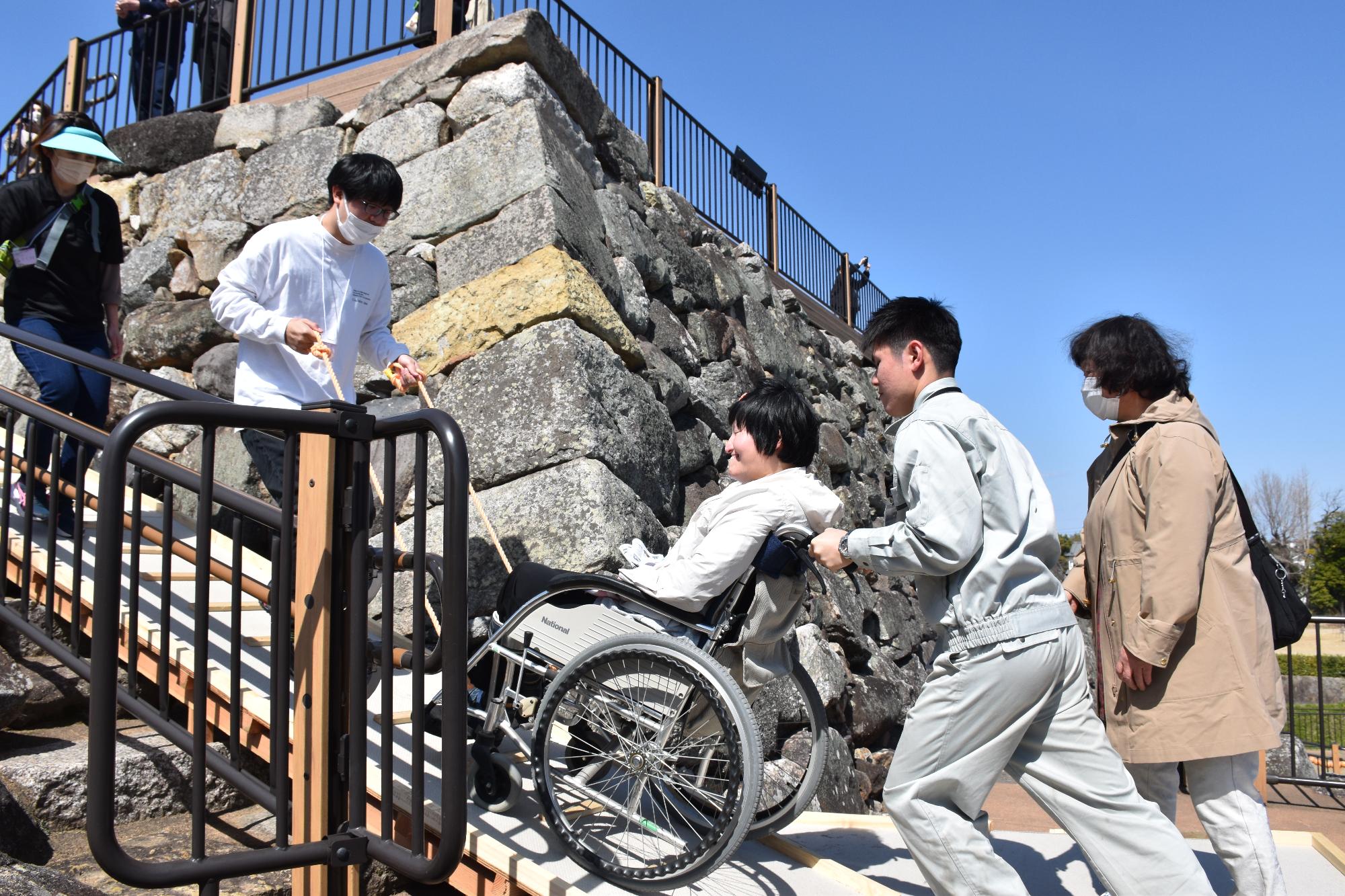 登城サポートにより、車いすに乗った方が郡山城天守台を登る様子