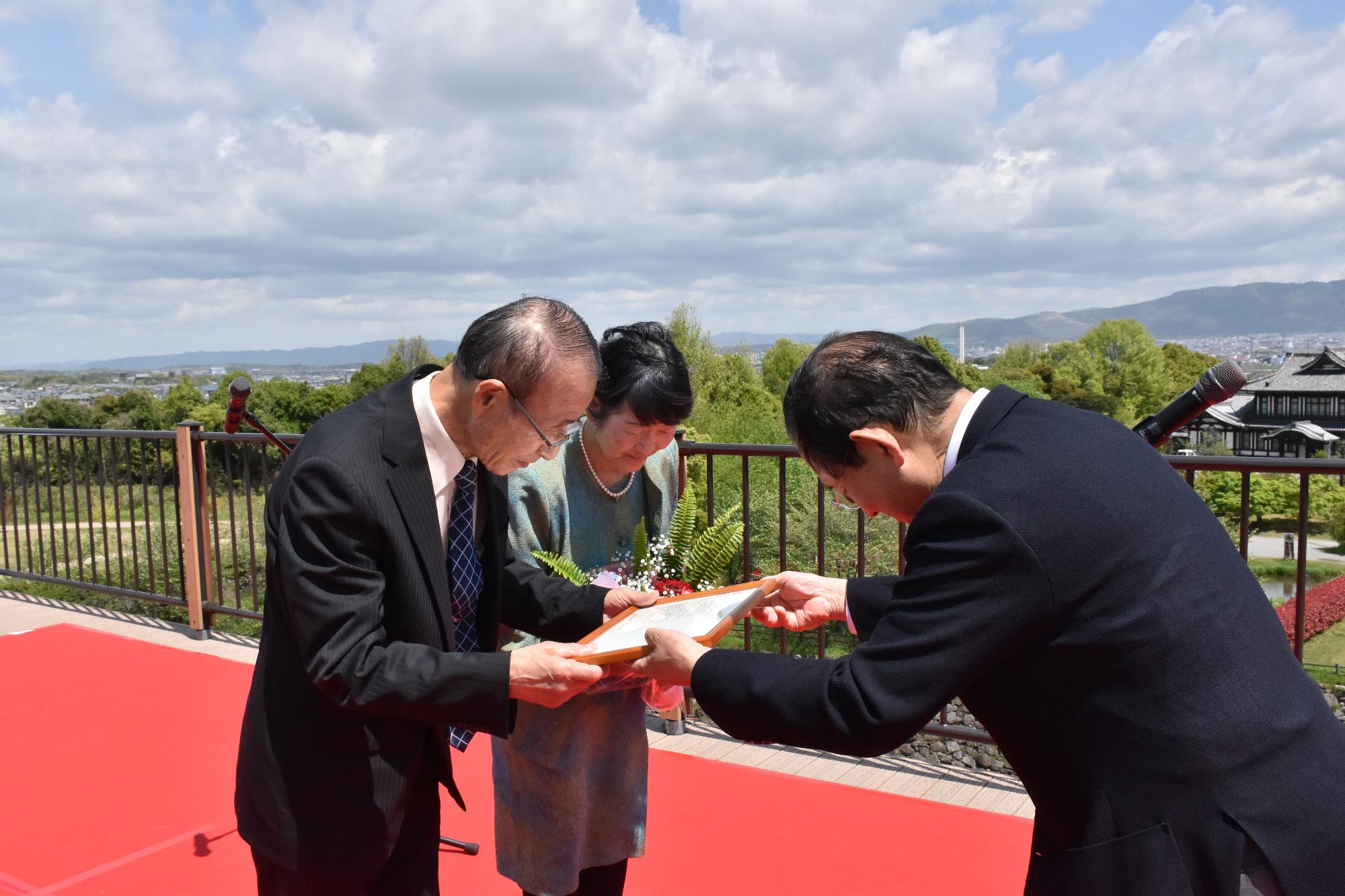 上田市長からご夫婦に感謝状を贈呈する様子