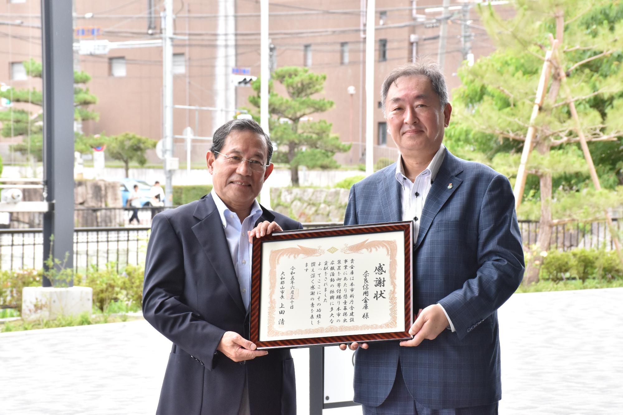 懸垂幕掲出装置の寄贈に対して、上田市長から奈良信用金庫の菊澤理事長へ感謝状が贈呈された