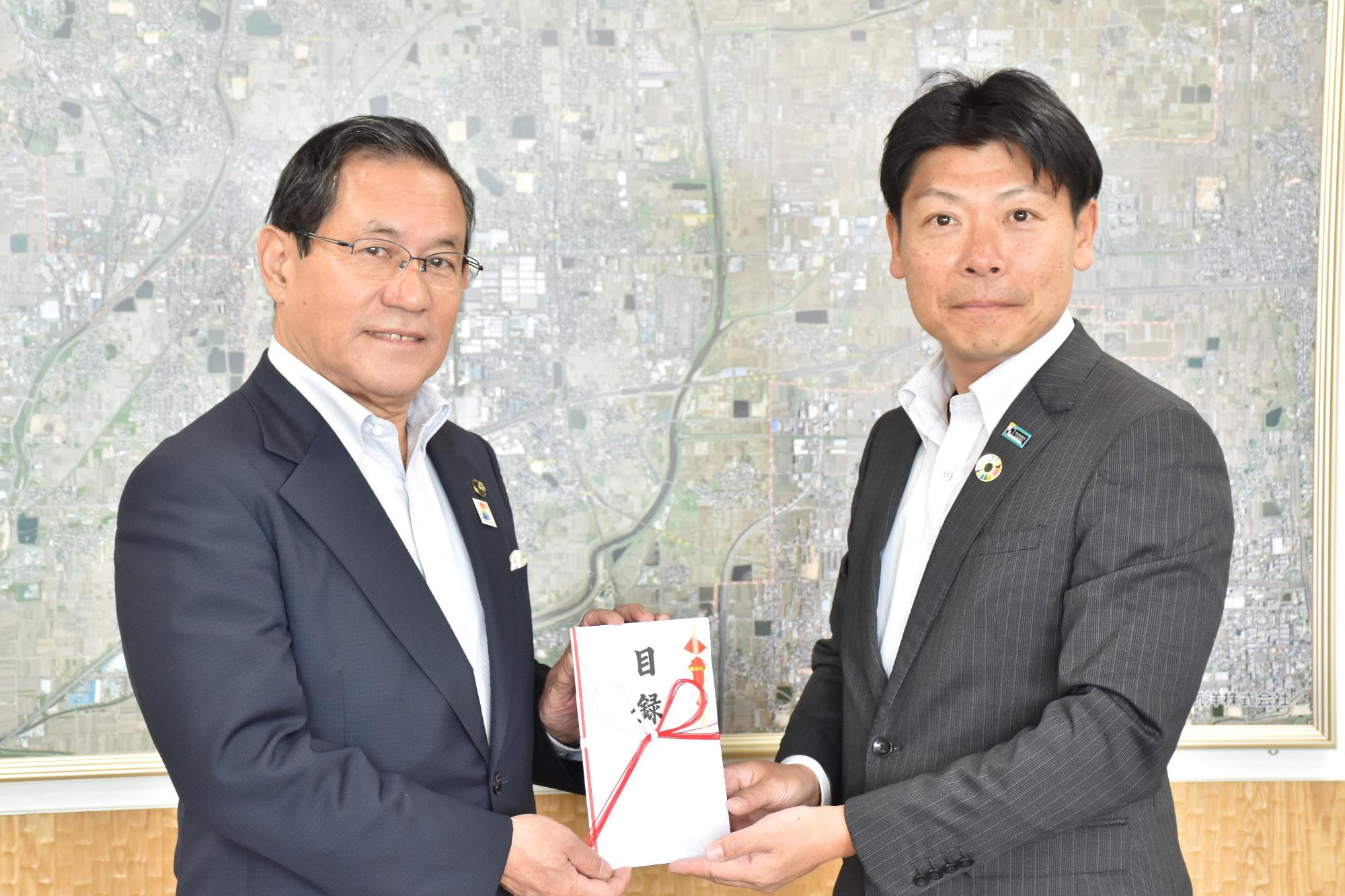 明治安田生命保険相互会社様から上田市長へ寄附の目録が贈呈されている様子