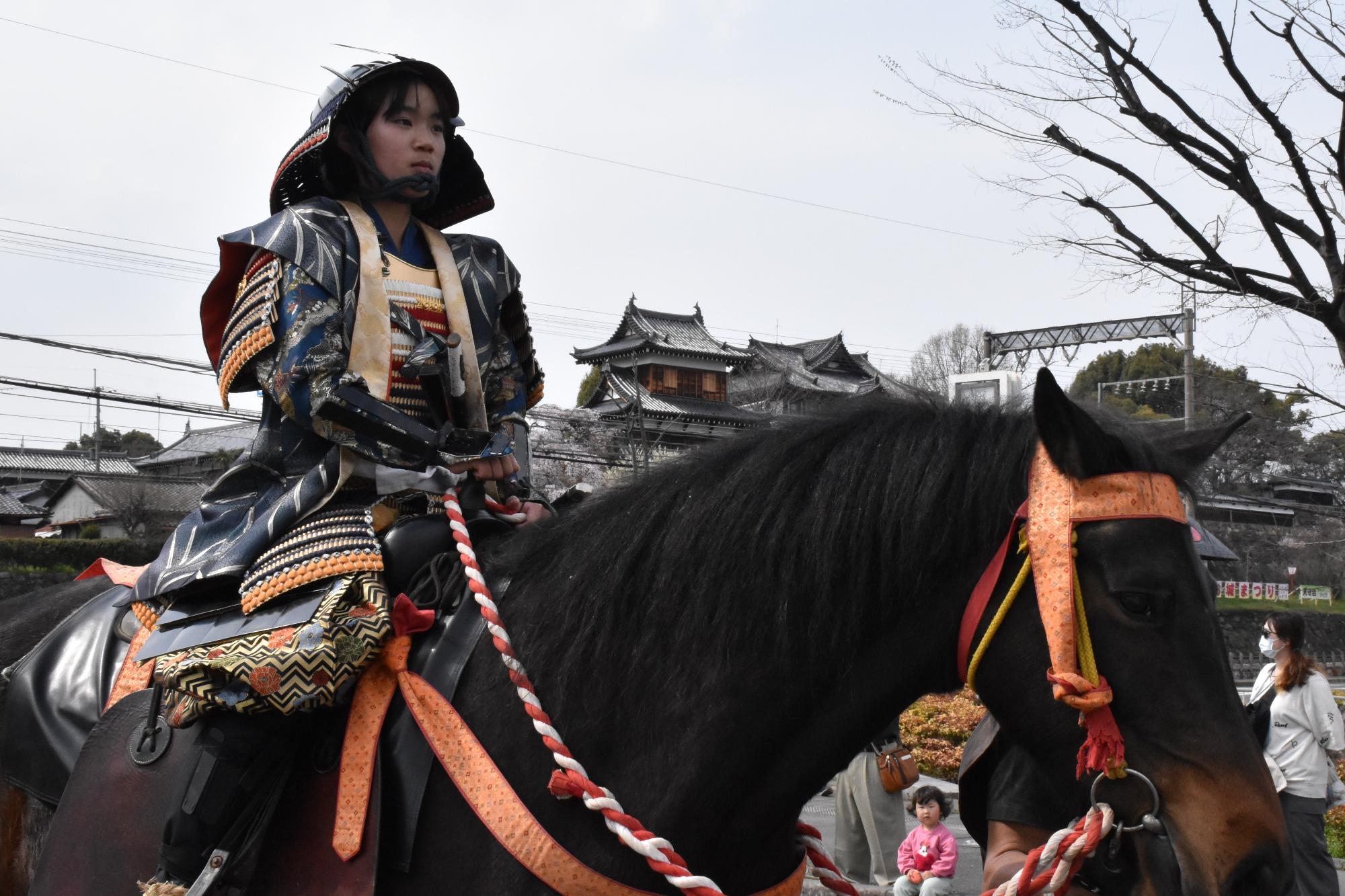 時代行列で武将姿に扮し馬に騎乗する市内小学生