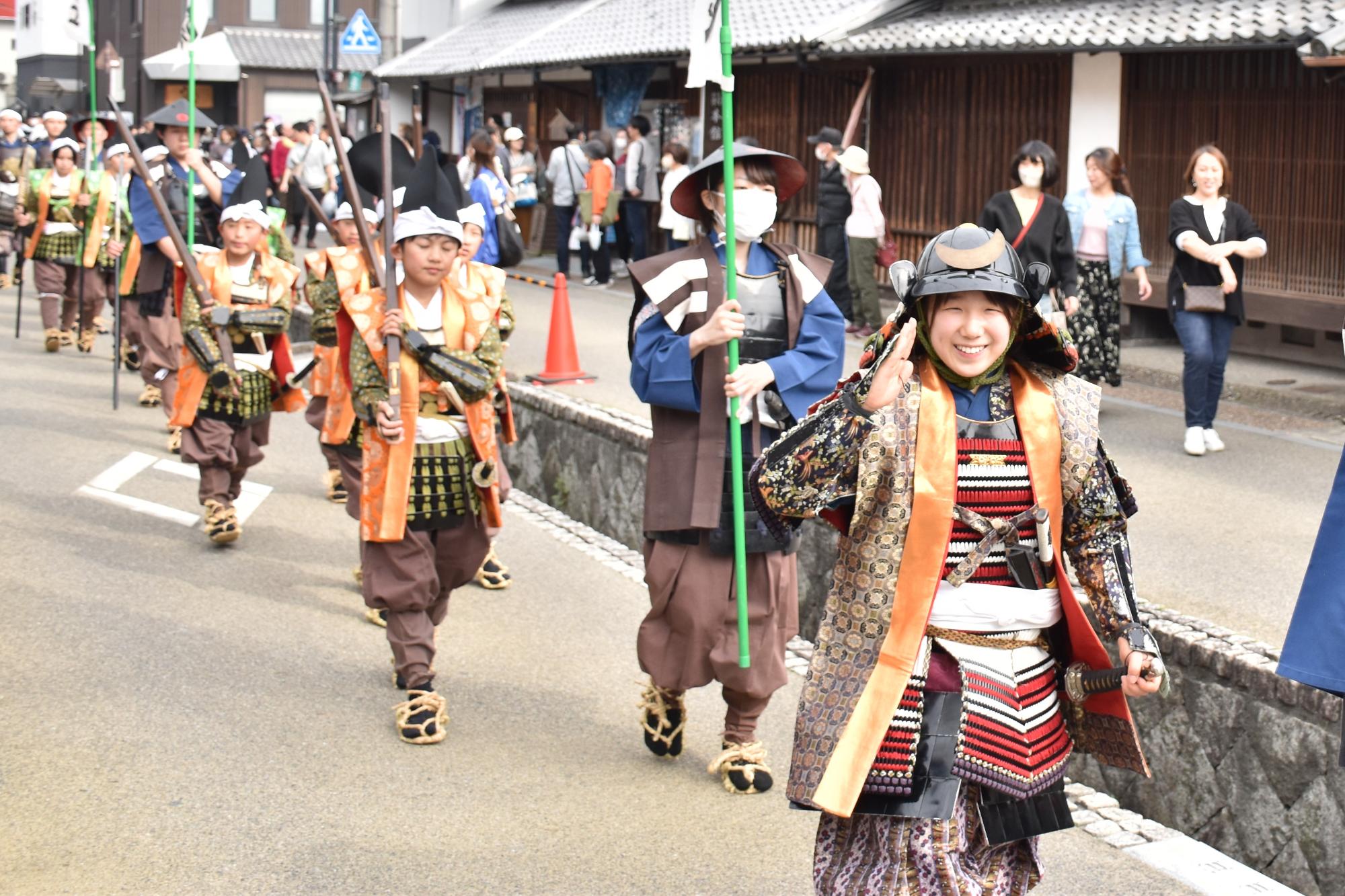 時代行列で紺屋川の横を練り歩く様子