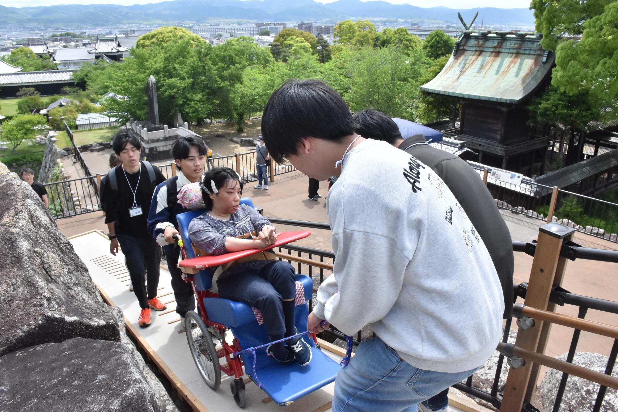 郡山城登城サポート ボランティアスタッフのサポートを受けて車椅子で登城する様子