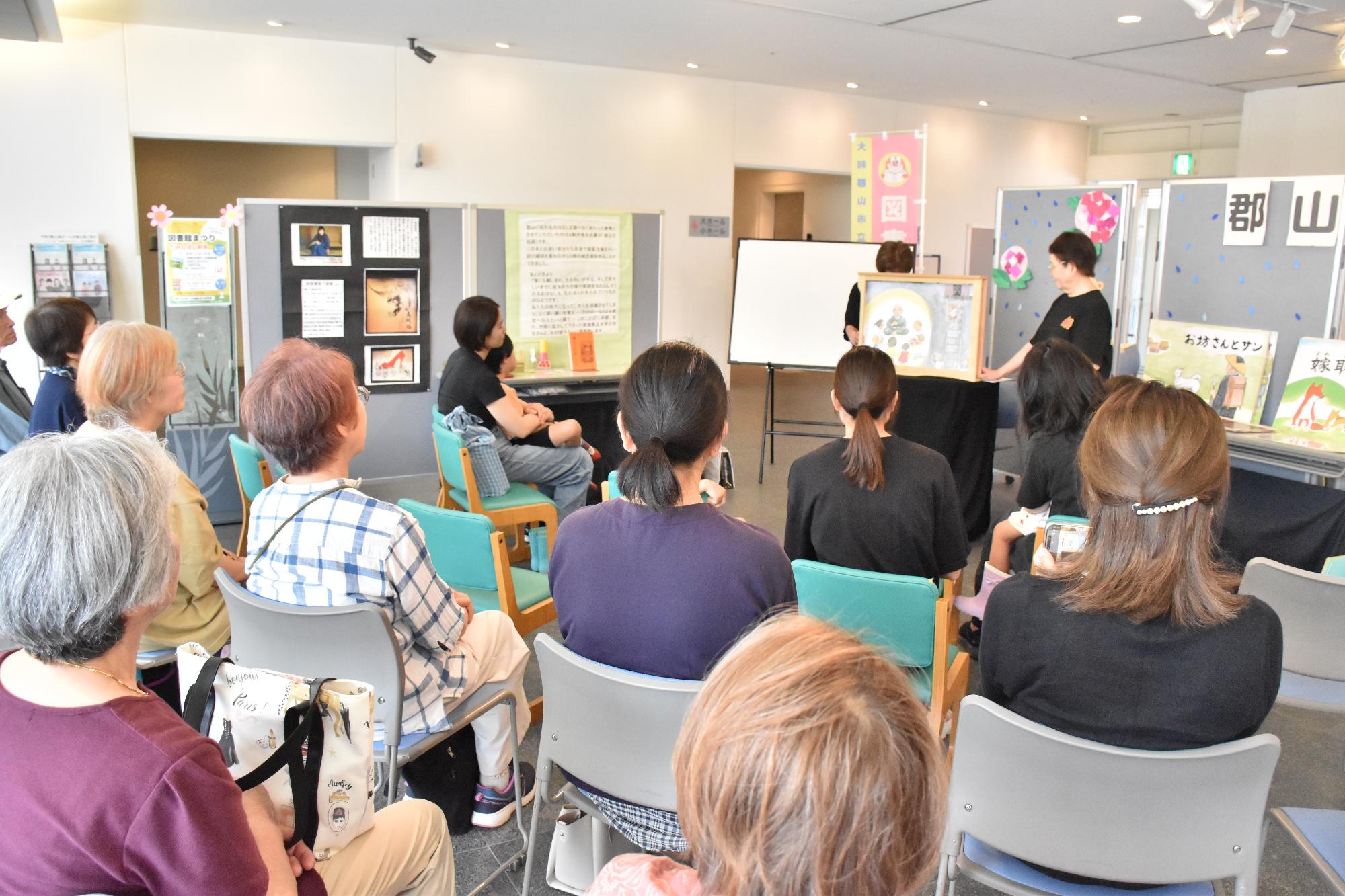 図書館まつりで紙芝居の読み聞かせを楽しんでいる観客