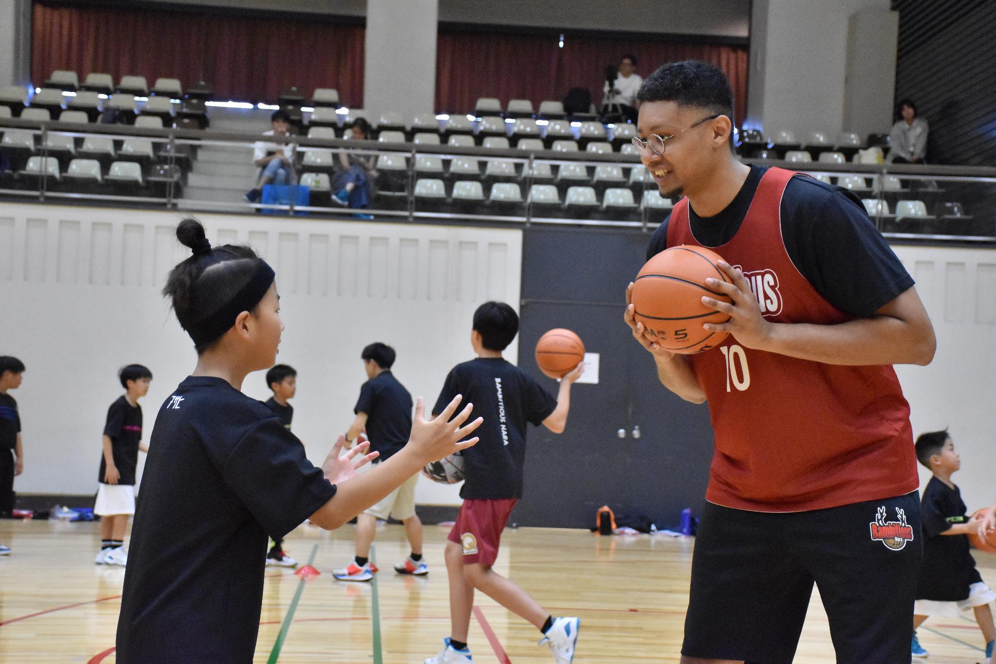 バスケットボール教室でプロの選手から指導を受ける小学生