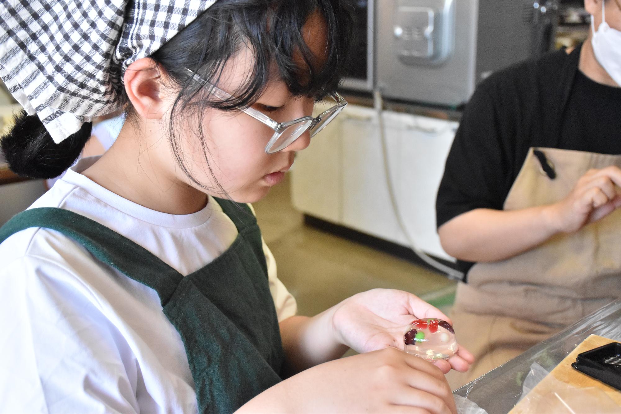 出来上がった金魚和菓子を手に取る女性