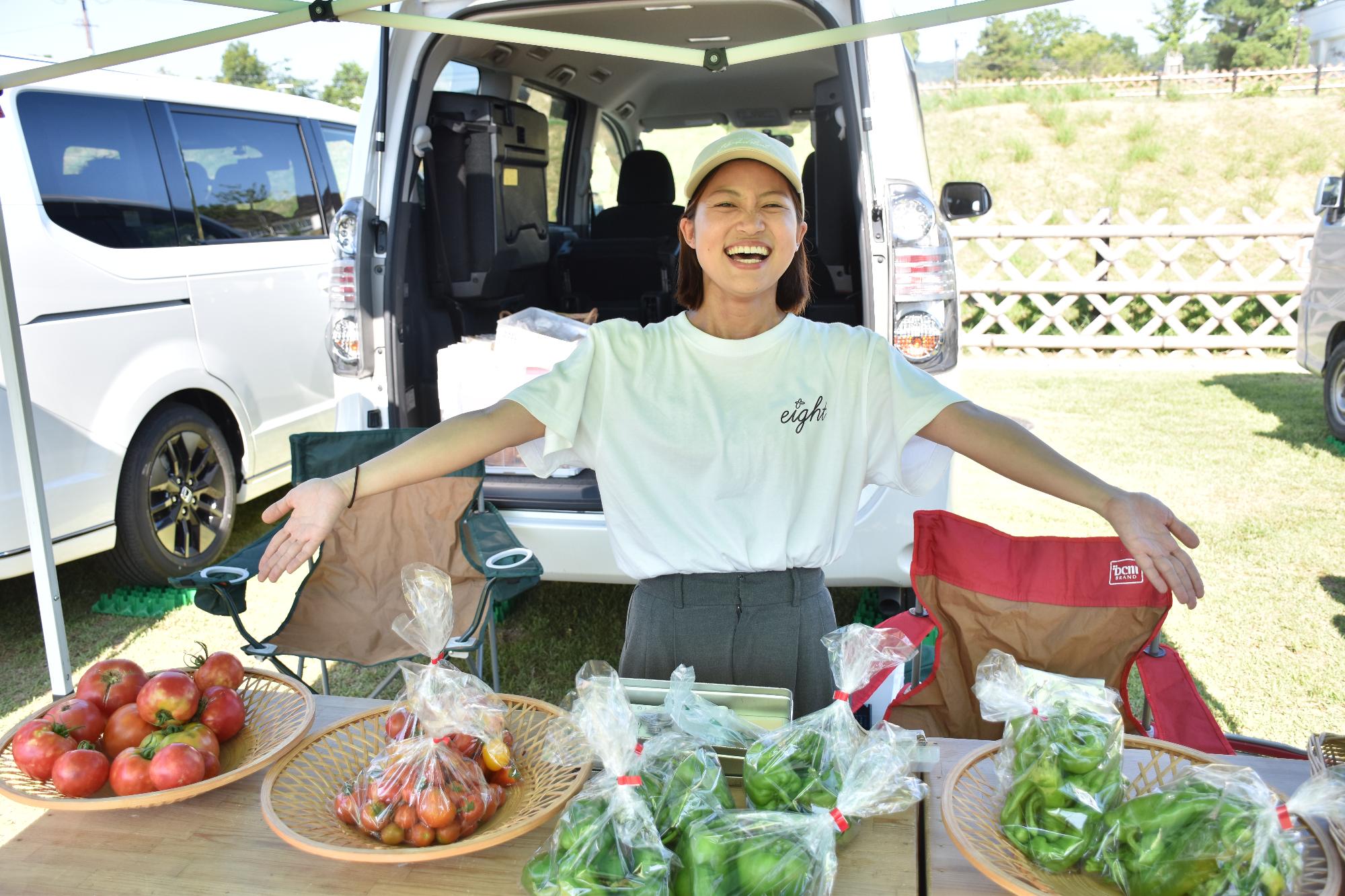 郡山市の日で夏野菜を笑顔でおすすめする女性