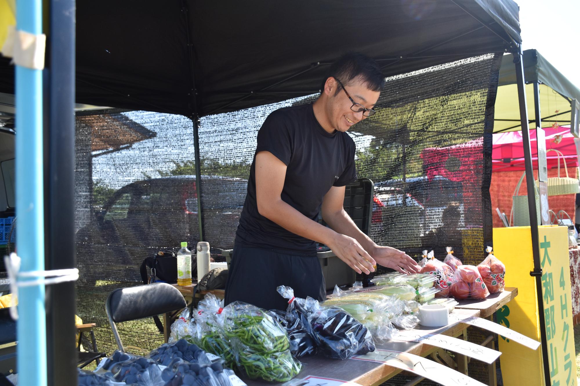 郡山市の日で夏野菜を販売する男性