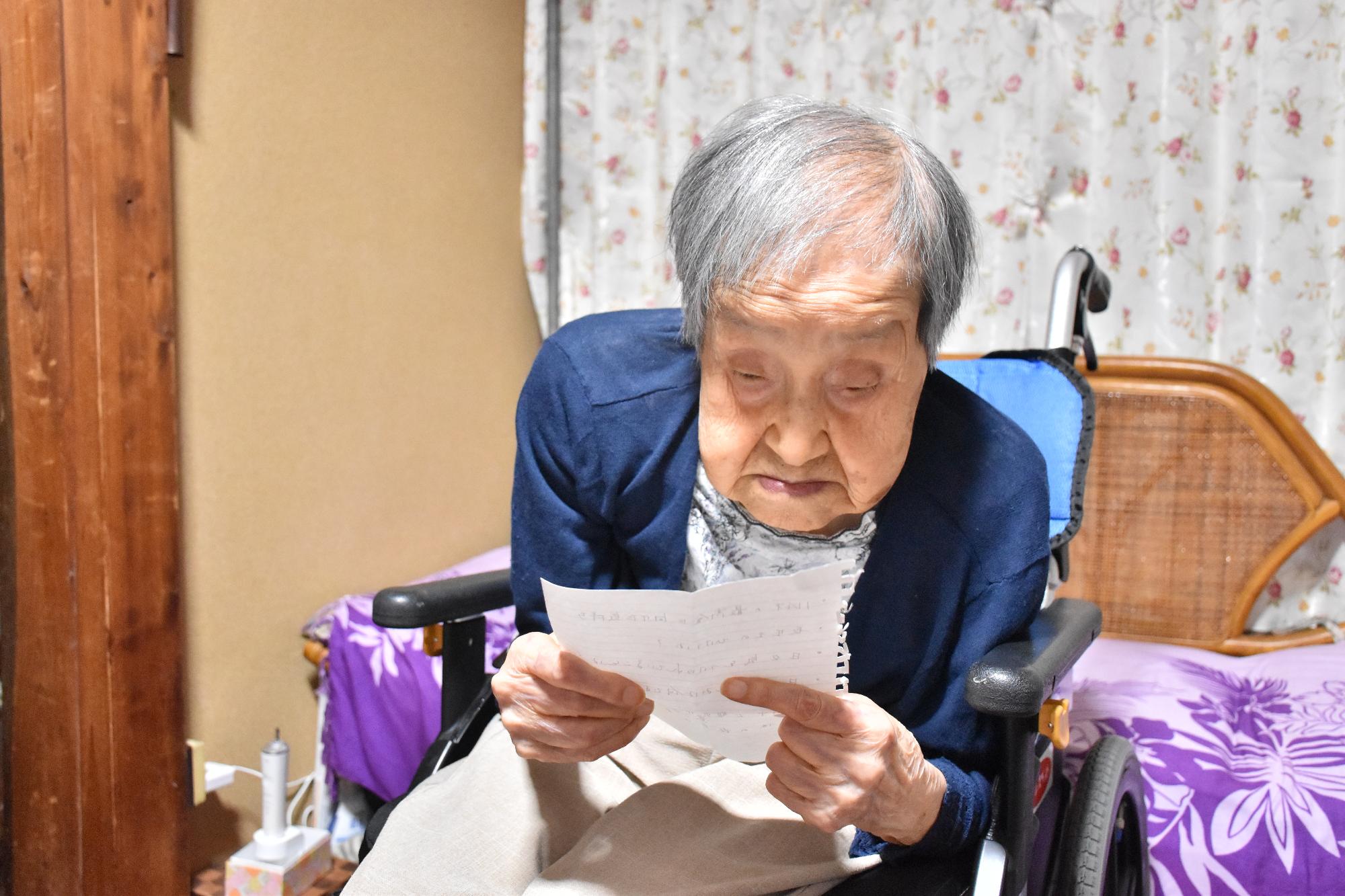賀川さんが職員が持参したメモを読む様子