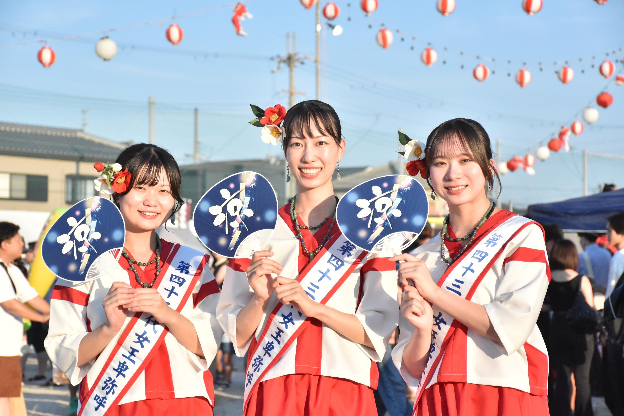 第49回大和の夏祭りで女王卑弥呼が祭りのうちわを見せている