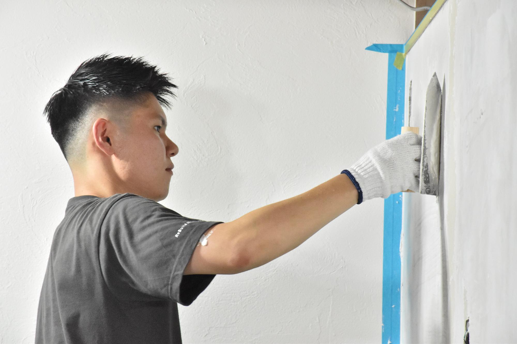 真剣な表情で左官作業を体験する男性