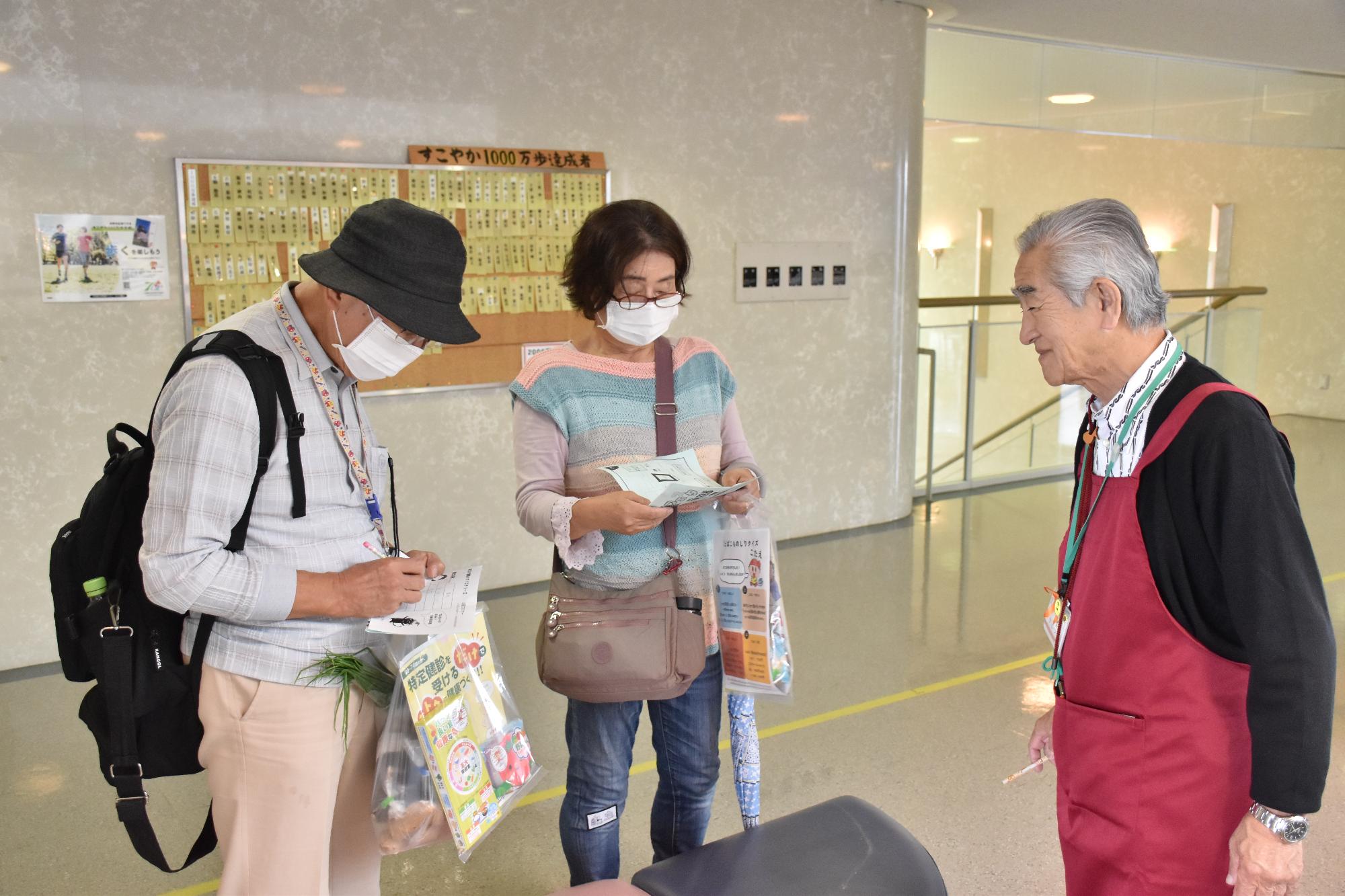 第20回すこやか21健康フェスタでクイズラリーをする来場者2名