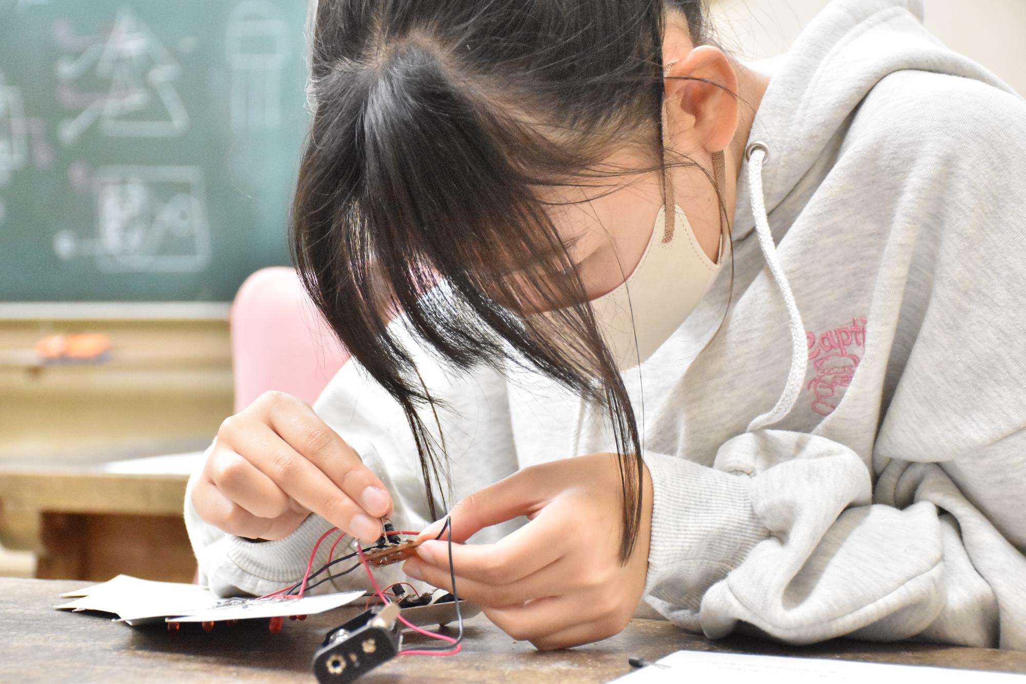 科学教室で細かい部品を集中して扱う受講生