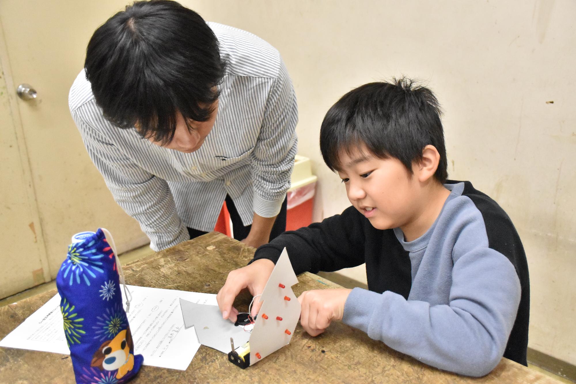 科学教室で先生から組み立て方を教わる受講生