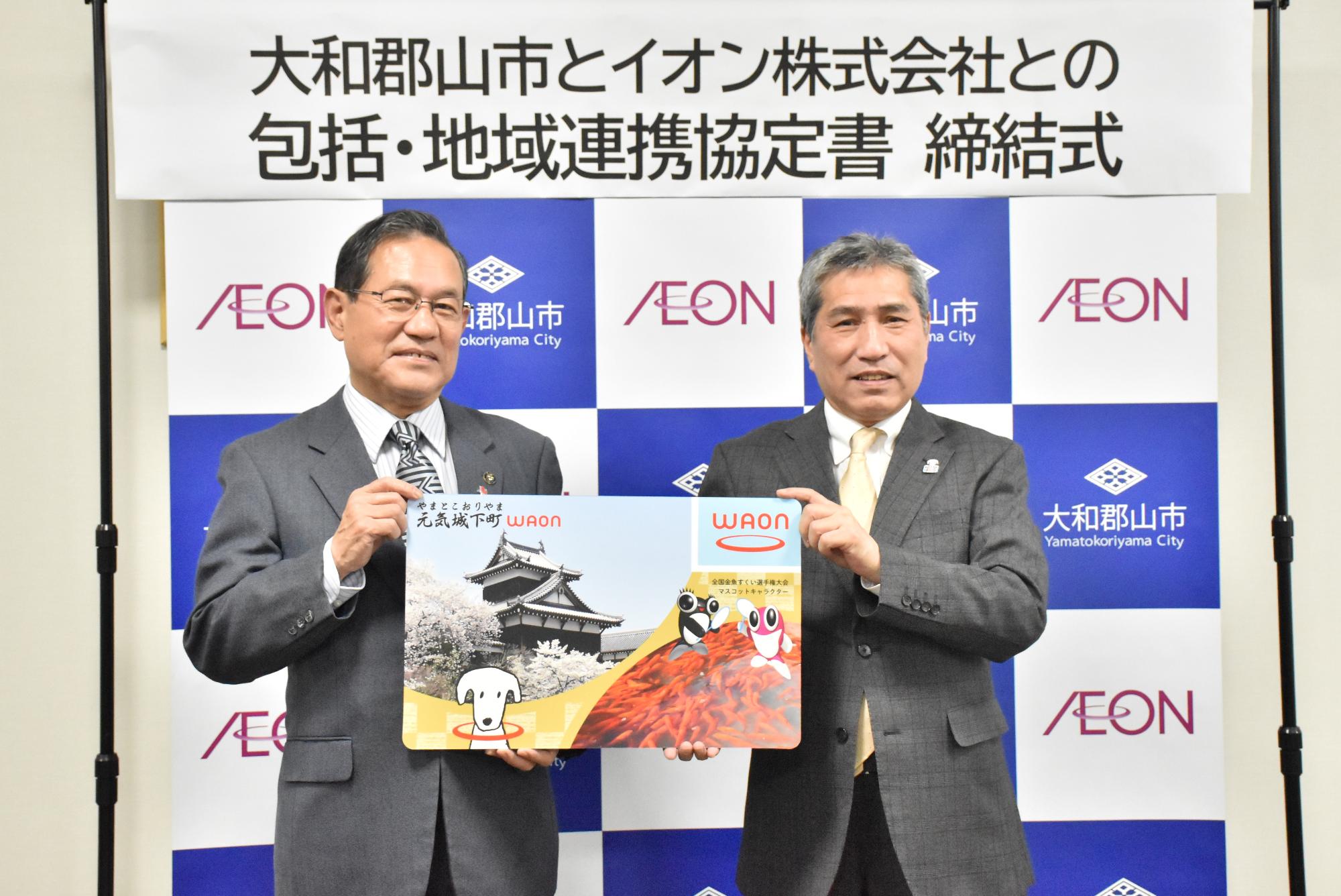 大和郡山とイオン株式会社との包括連携協定書締結式にてご当地ワオンをお披露目する様子