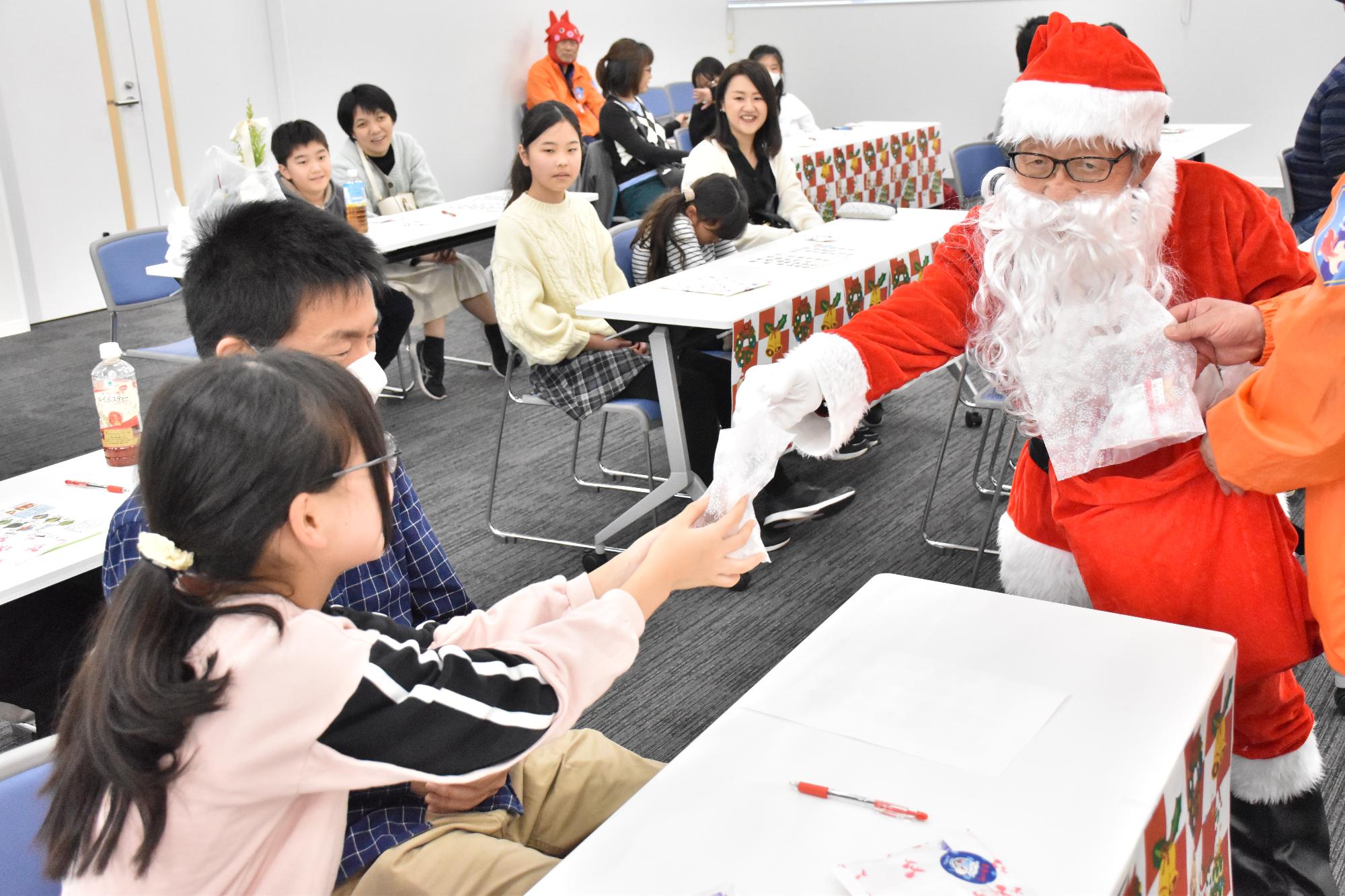 金魚マイスタークリスマススペシャルイベント2025でサンタからプレゼントを受け取る子ども