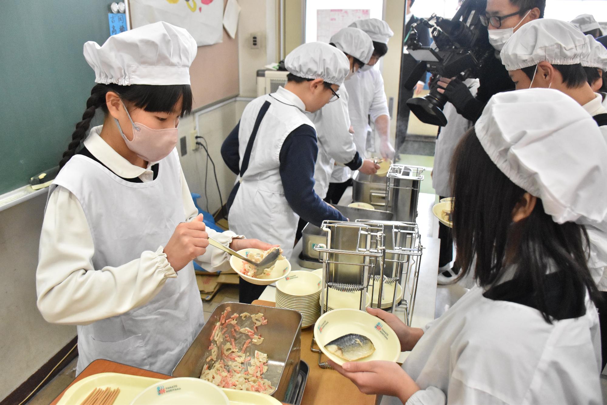 秀長さん給食を配膳する子どもたち