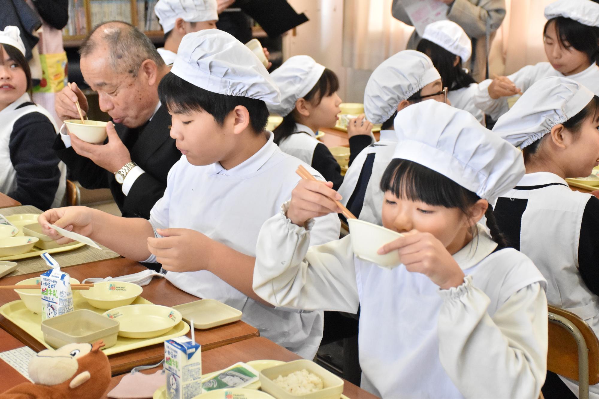 秀長さん給食を美味しそうに食べる児童