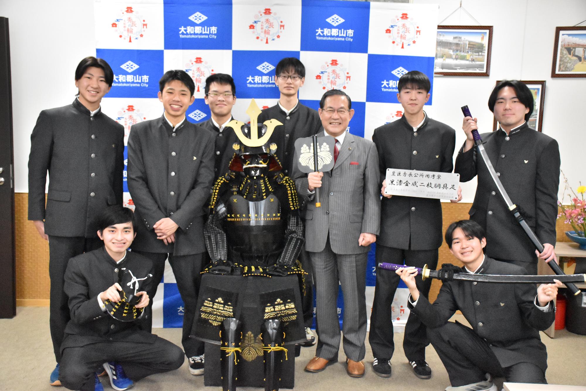 奈良商工高校の生徒が製作した豊臣秀長の甲冑を囲み、生徒と市長が記念撮影