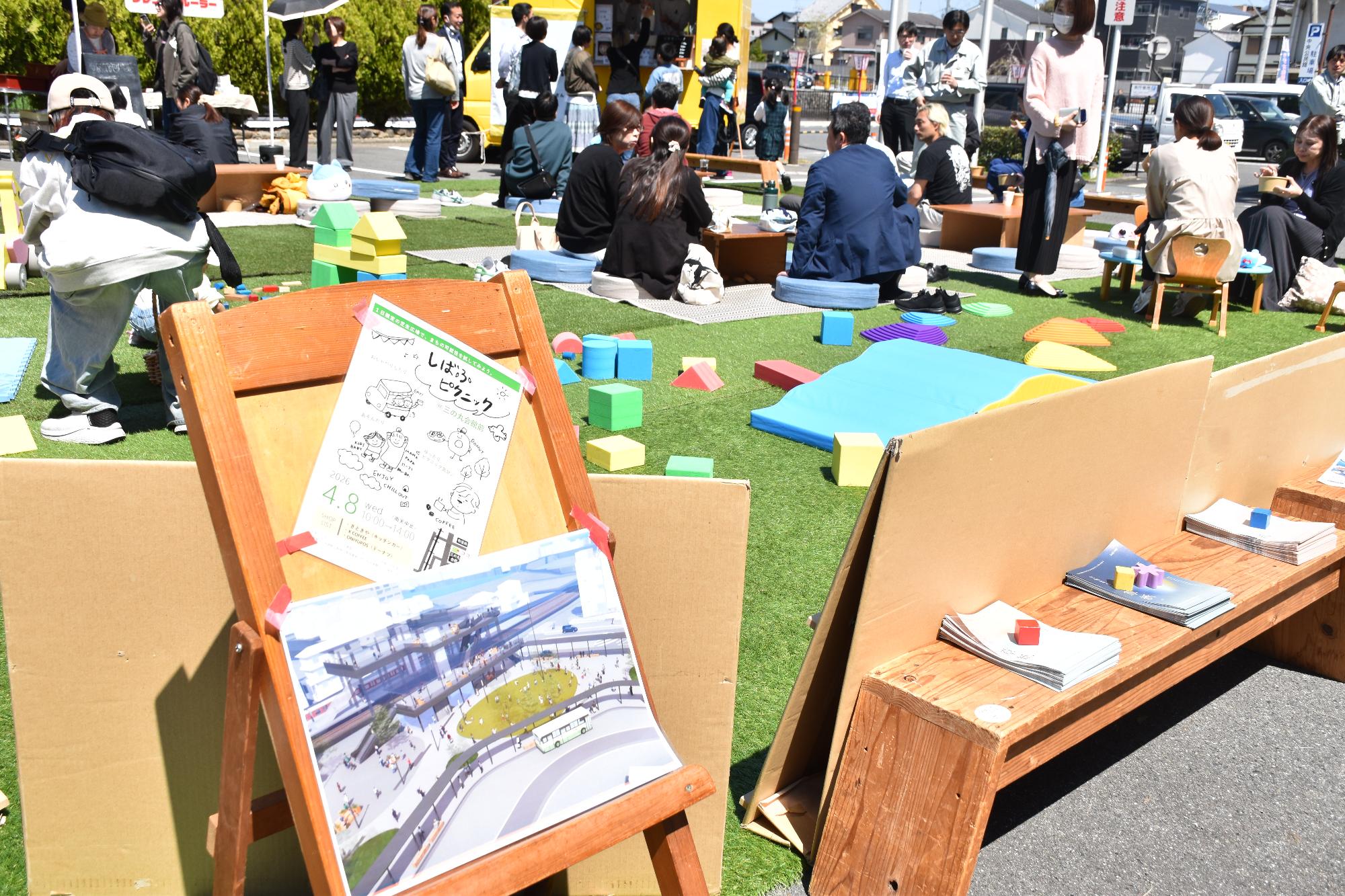 芝生の上に机やクッションがありたくさんの人がくつろいでいる様子