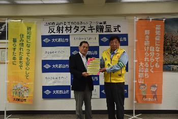 タスキの贈呈を受ける市長と贈呈者