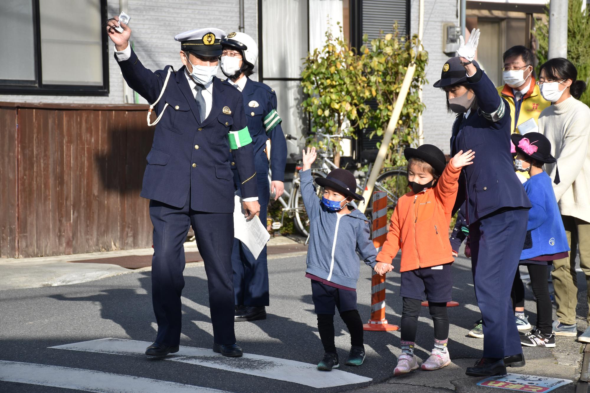 実際に横断歩道を渡る幼稚園児2人とそれを補助する大人2人