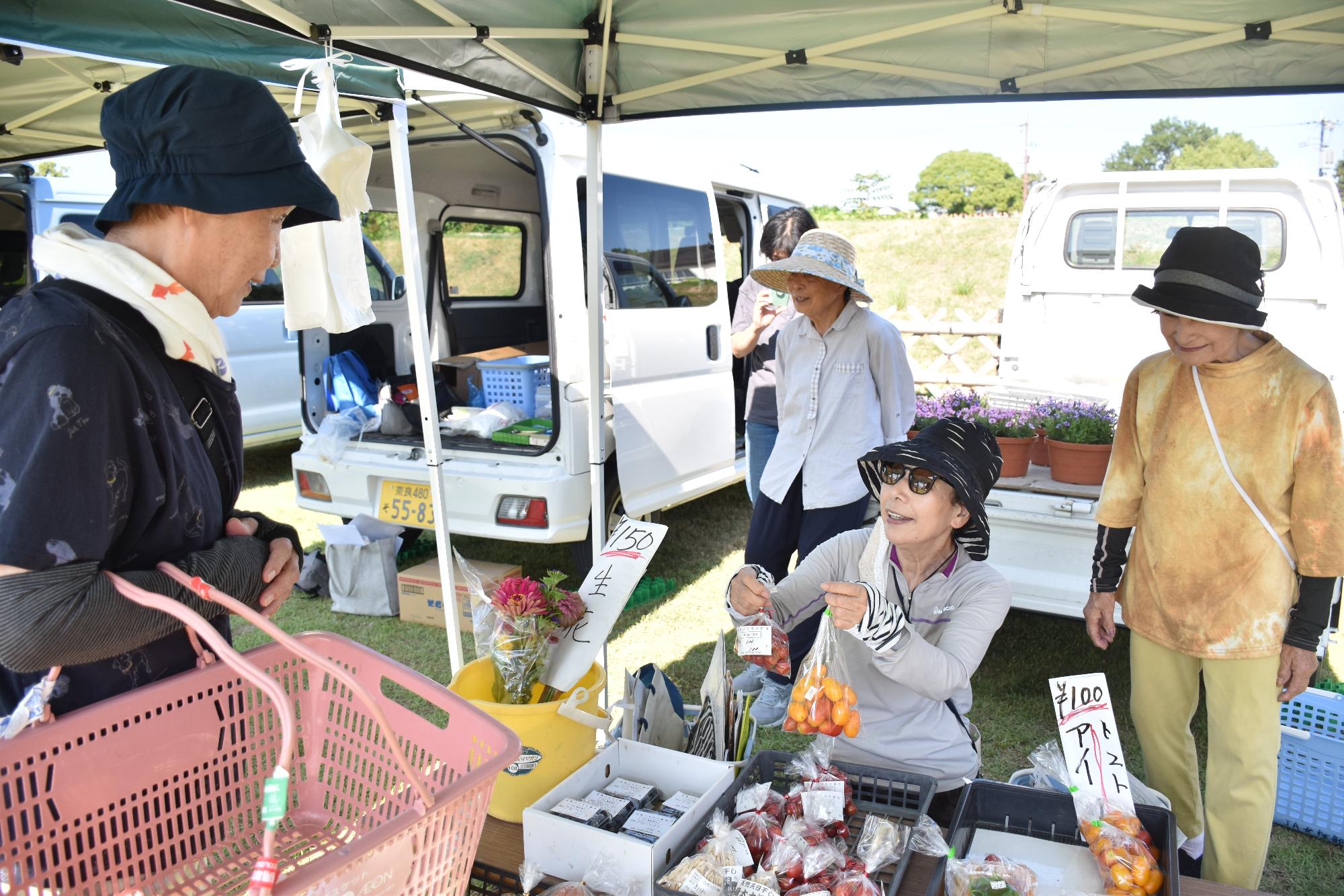 郡山・市の日で出店者とお話をしながらお買い物を楽しむ人