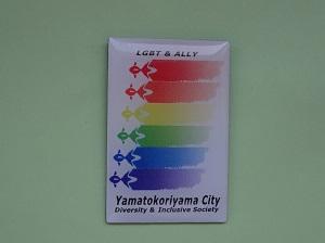 LGBTレインボーマークが印刷された四角いピンバッジの写真