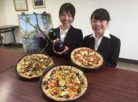 2017年度の記者会見で3種類のピザをPRしている大原聖香さんと米山茄那さんの写真