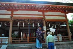 神社の前で男性がお祓いを受けている写真