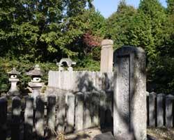 奥に石灯籠や他の敷地の墓石がある忠常公の実姉の禄姫さんのお墓の写真