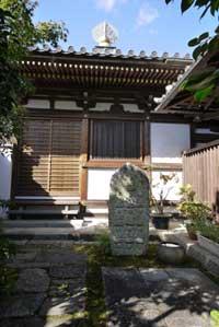日本家屋の前に立つ銅像の写真