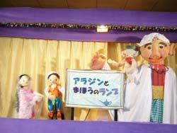 人形劇に出てくる人形と劇のタイトル「アラジンと魔法のランプ」を出している写真