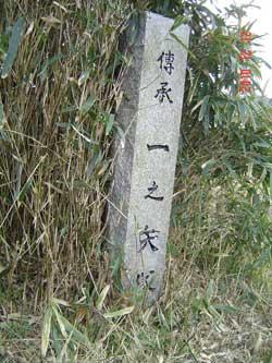 草の中に建てられた「一の矢塚」石柱の写真