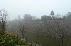 霧のかかるお城のお堀の写真