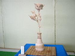 竹製の花瓶にさしてある竹製のバラの写真