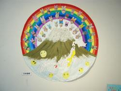 富士山に虹のかかり、周りに笑顔が描かれた作品の写真