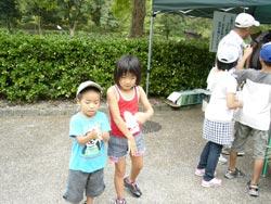 水色のTシャツの弟と赤いタンクトップの姉が竹トンボを持っている写真