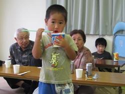 かき氷を食べる子どもと、それを見守るお年寄りの写真