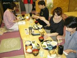 玄米ごはんを食事する4人の方々の写真