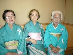 水色の着物を着た女性が3名並んで座っている写真